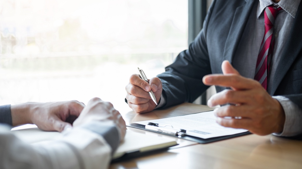 two people talking over documents on a table