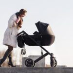 Woman pushing a stroller on a stone path_s