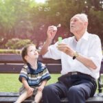 Old man blowing bubbles for a child_s