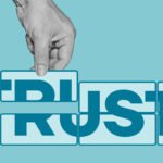 man’s hand forms the word trusts