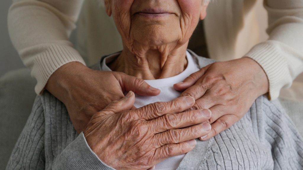 woman hugging mother from behind holding hands