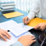Two people review legal documents at a desk with a gavel, scales of justice, and stacked law books_s