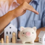 man-holding-hand-over-model-of-house-family-and-piggy-bank_s